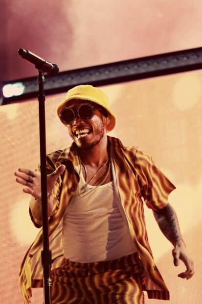 Anderson Paak is performing energetically with sunglasses and a yellow hat, HD Mobile Wallpaper