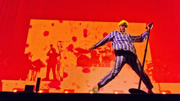 Anderson Paak performs energetically in front of vibrant red and orange lights, HD Desktop Wallpaper