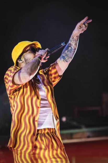 Anderson Paak is shown rapping during a concert wearing a yellow outfit, HD Mobile Wallpaper