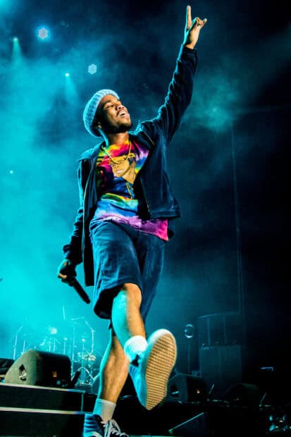 Anderson Paak is performing energetically during a concert with bright stage lights, HD Mobile Wallpaper