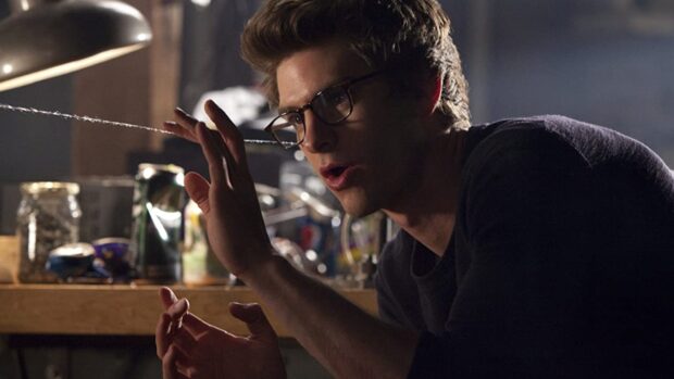 Andrew Garfield is seen inspecting a web line in a dimly lit room, HD Desktop Wallpaper