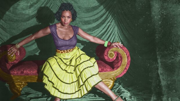 Angela Bassett poses in a colorful dress sitting on a vintage red and gold sofa, 2K Desktop Wallpaper