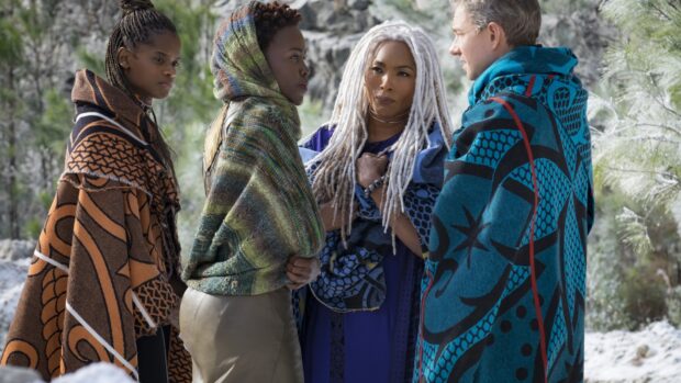 Angela Bassett with cast members standing outdoors wearing unique cloaks, HD Desktop Wallpaper
