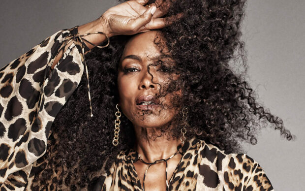 Angela Bassett with voluminous curly hair posing wearing a leopard print blouse, 2K Desktop Wallpaper