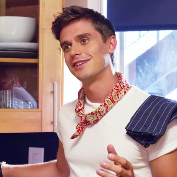 Antoni Porowski smiles while standing in a kitchen setting with a red bandana around his neck, HD Desktop Wallpaper