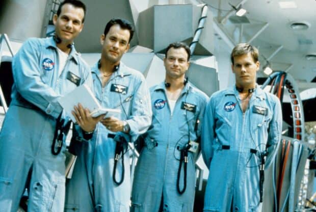 Four Apollo 13 crew members standing in blue NASA suits inside a spacecraft, HD Desktop Wallpaper