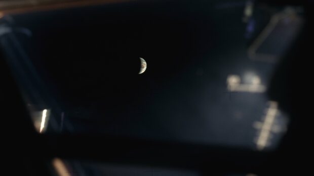 The Apollo 13 mission shows Earth partially lit seen through a spacecraft window, 4K Desktop Wallpaper