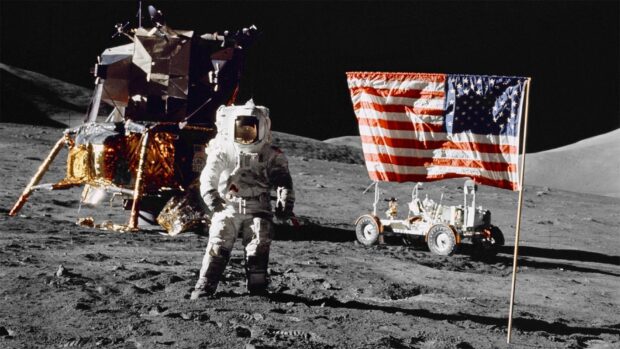 An astronaut stands on the moon with a flag and lunar module, HD Desktop Wallpaper