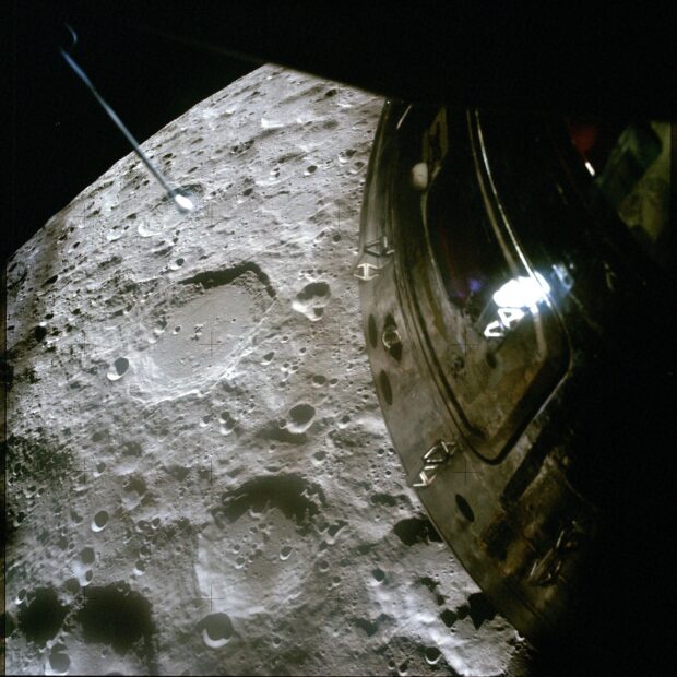 The Apollo 13 spacecraft is seen orbiting the moon with the cratered lunar surface below, HD Desktop Wallpaper