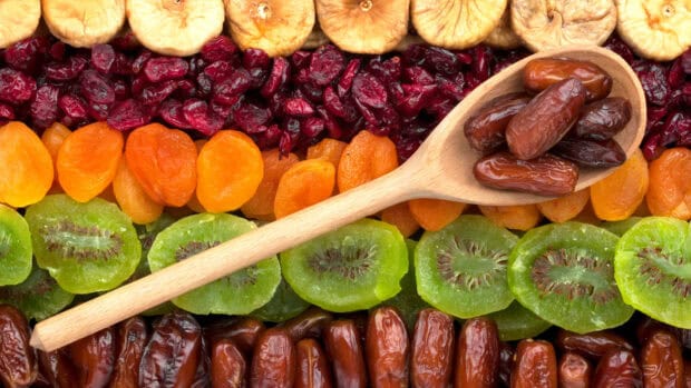 A wooden spoon with dates lies on a variety of dried apricots and fruits, HD Desktop Wallpaper