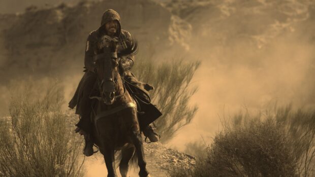 An assassin rides a horse through a dusty desert scene from Assassins Creed movie, 4K Desktop Wallpaper