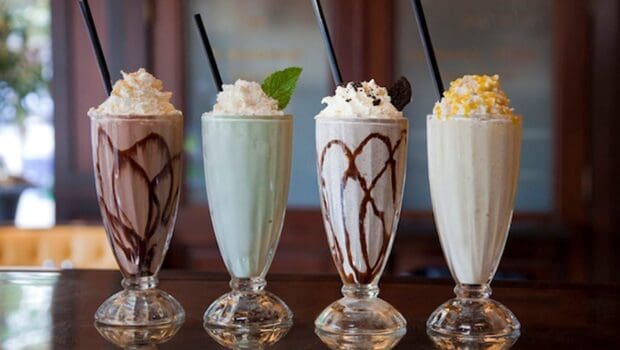 Four tall milkshakes with whipped cream and straws on a table, HD Desktop Wallpaper