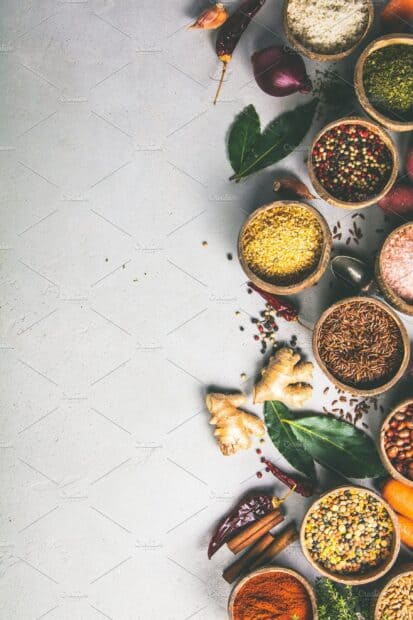 An arrangement of seasoning includes spices and herbs in wooden bowls on a gray surface, 2K Mobile Wallpaper