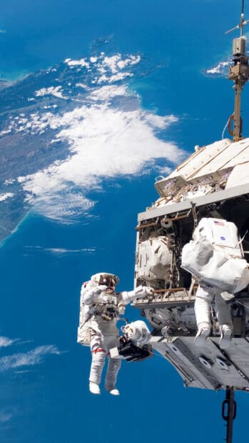 Two astronauts perform maintenance outside the space station orbiting Earth, HD Mobile Wallpaper