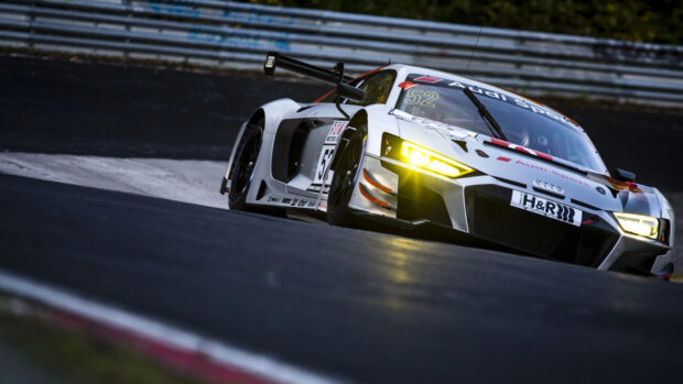 An Audi race car speeds along a dark track with glowing headlights during a competition, 4K Desktop Wallpaper