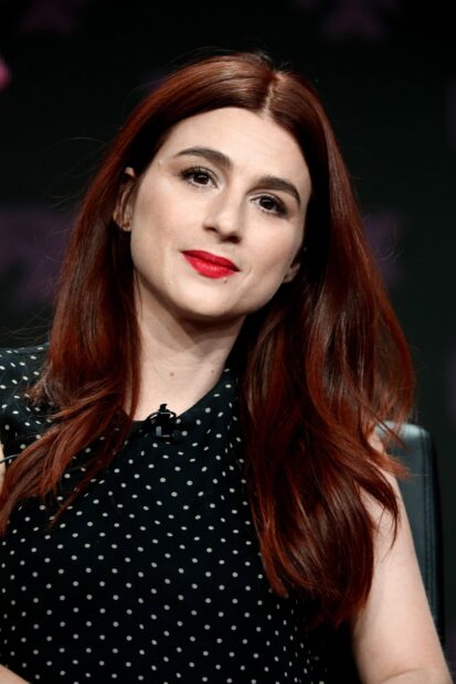 Aya Cash with long red hair and red lipstick looking ahead, 2K Mobile Wallpaper
