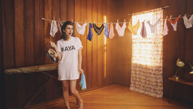 Aya Cash is standing holding an iron with clothes hanging on a line, 4K Desktop Wallpaper