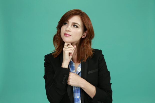 Aya Cash looks thoughtful wearing a black jacket against a teal background, HD Desktop Wallpaper