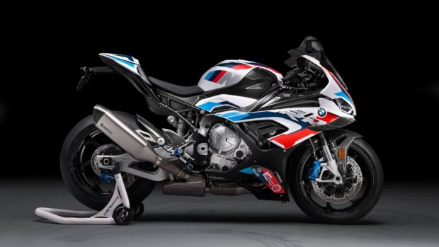 A BMW M 1000 RR motorcycle with blue and red accents is displayed in a studio setting, 4K Desktop Wallpaper