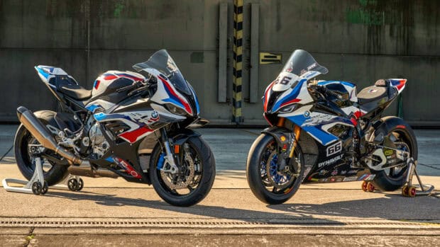 Two BMW M 1000 RR motorcycles with racing decals parked side by side in a garage, HD Desktop Wallpaper