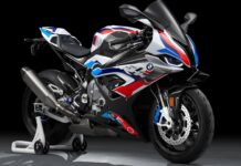 A BMW M 1000 RR is showcased with its detailed design and colors against a dark studio background, 2K Desktop Wallpaper