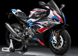 A BMW M 1000 RR is showcased with its detailed design and colors against a dark studio background, 2K Desktop Wallpaper