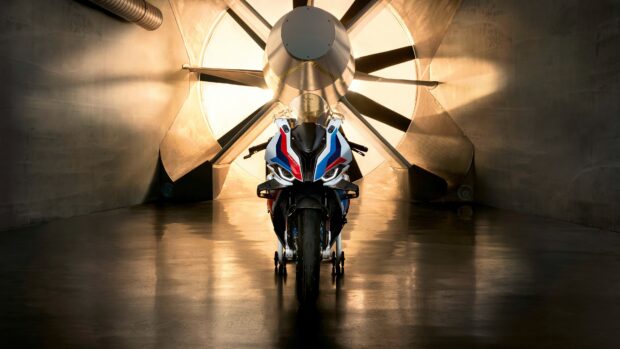 The BMW M 1000 Rr is shown in front of a large industrial fan, highlighting its design, 4K Desktop Wallpaper