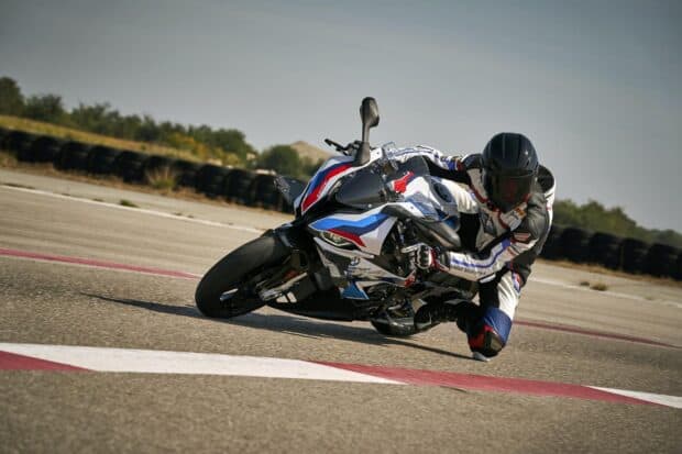 A rider leans into a sharp turn on a BMW M 1000 Rr motorcycle during a race, HD Desktop Wallpaper