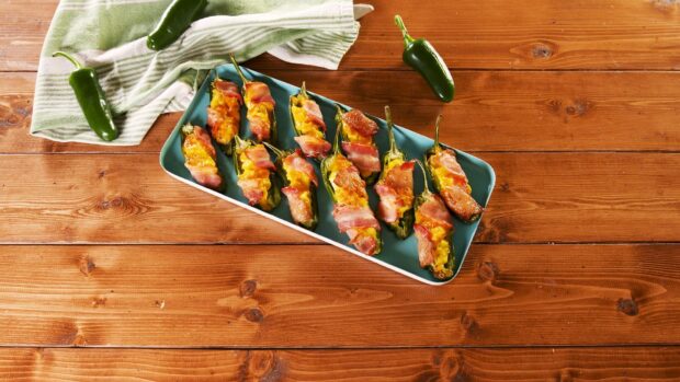 A plate of jalapeno appetizers stuffed with cheese and wrapped in bacon on a wooden table, HD Desktop Wallpaper