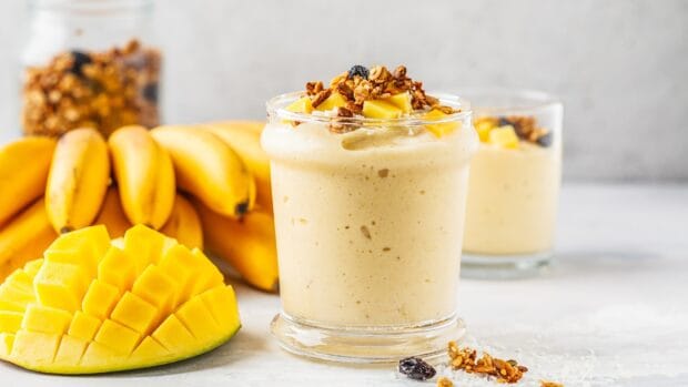 A creamy banana mango milkshake topped with granola is ready to serve, HD Desktop Wallpaper