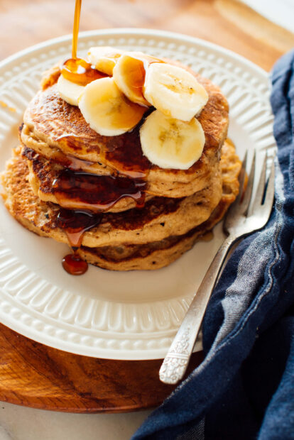 A stack of banana topped pancakes with syrup dripping on a white plate, 2K Mobile Wallpaper