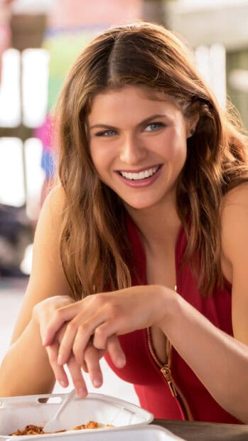 A woman from Baywatch movie is smiling happily while sitting at a table, 2K Mobile Wallpaper