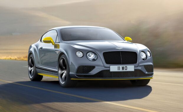 A Bentley Continental GT car with yellow accents driving on a highway under cloudy skies, 2K Desktop Wallpaper