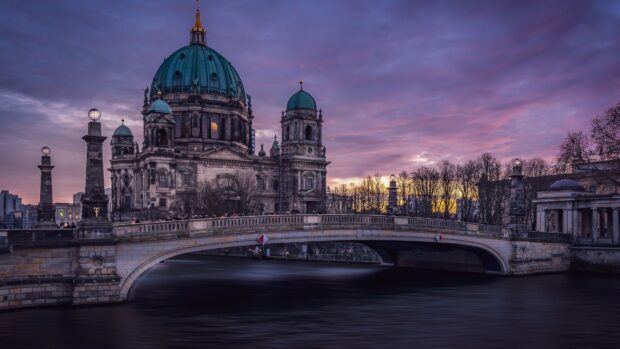 The Berlin Cathedral stands beside the river under a purple sunset sky, 4K Desktop Wallpaper