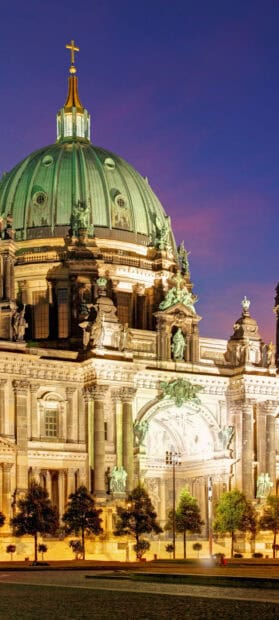 The Berlin Cathedral is illuminated against the evening sky showcasing its intricate architecture, 2K Mobile Wallpaper