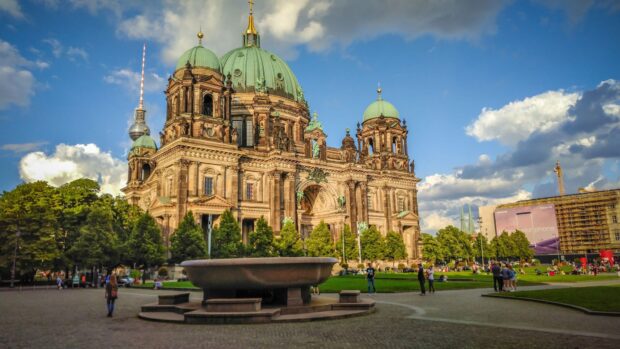 The Berlin Cathedral stands prominently in a park with visitors enjoying the sunny weather, 4K Desktop Wallpaper