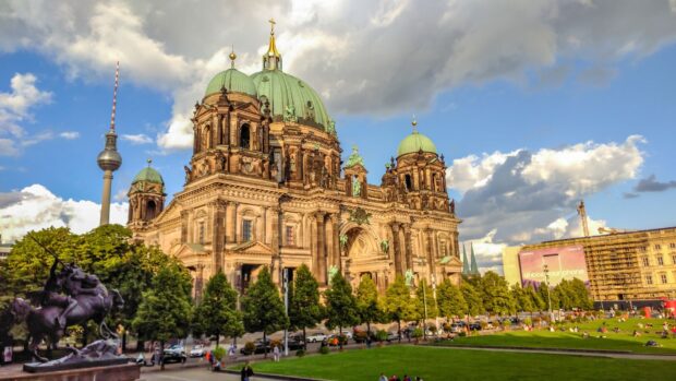 The Berlin Cathedral stands tall under a partly cloudy sky surrounded by green park and visitors, HD Desktop Wallpaper