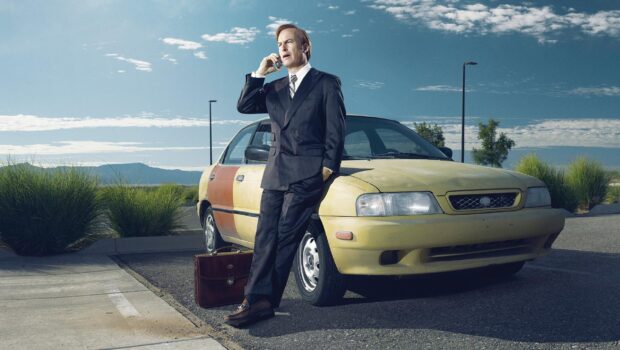A man in a suit talks on the phone beside an old car outside, HD Desktop Wallpaper