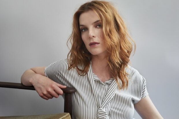 Betty Gilpin poses wearing a striped shirt with wavy hair and a neutral expression, 2K Desktop Wallpaper