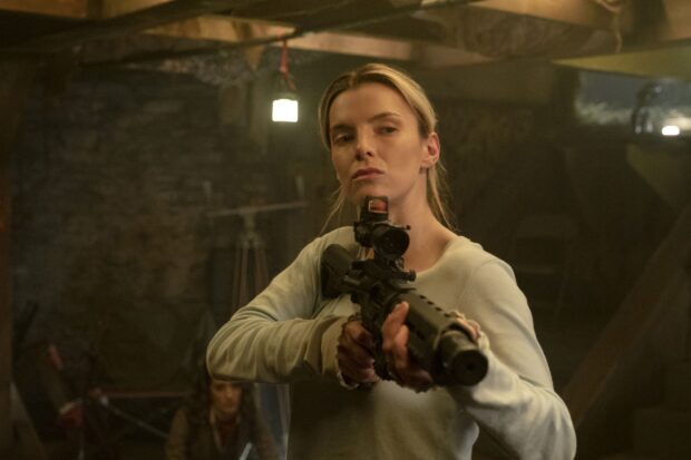Betty Gilpin holding a rifle in a dimly lit room with a focused expression, 2K Desktop Wallpaper