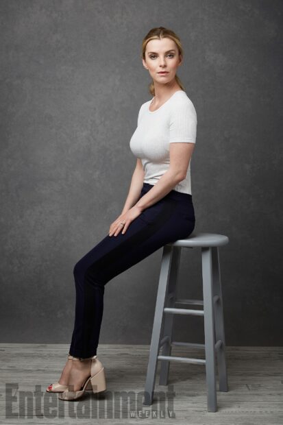 Betty Gilpin is sitting on a stool wearing a white top and dark pants, HD Mobile Wallpaper