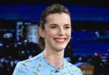 Betty Gilpin is smiling warmly while wearing a blue floral dress during a talk show, HD Desktop Wallpaper