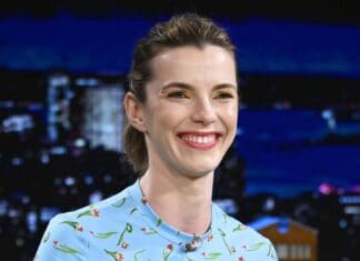 Betty Gilpin is smiling warmly while wearing a blue floral dress during a talk show, HD Desktop Wallpaper