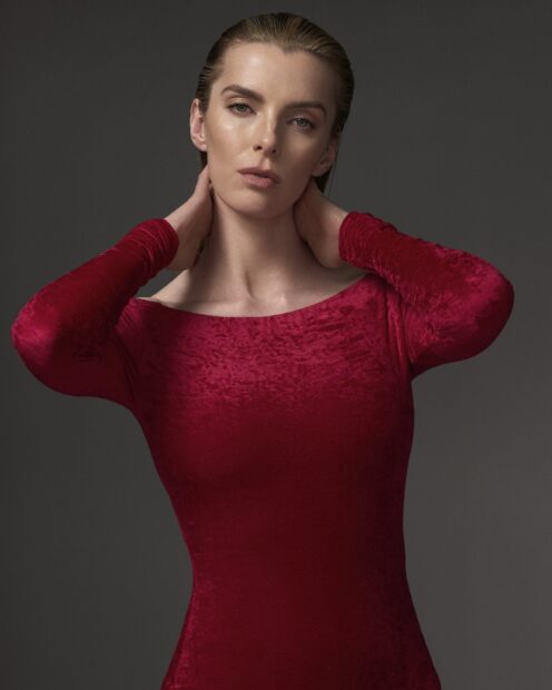 Betty Gilpin Wallpapers feature a close up portrait of Betty Gilpin in a red dress with a neutral background, HD Phone Wallpaper