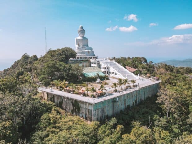 The Big Buddha statue stands tall on a lush Phuket mountain under a blue sky, 2K Desktop Wallpaper