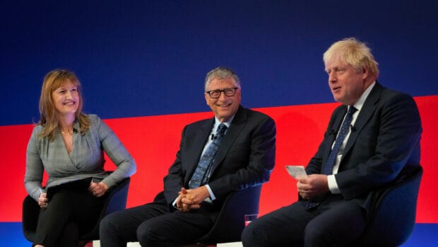 Bill Gates is smiling during a panel discussion with two other individuals, HD Desktop Wallpaper