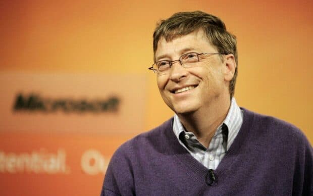 Bill Gates smiling during an event with an orange Microsoft background, HD Desktop Wallpaper