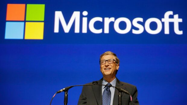 Bill Gates is speaking at a podium with a Microsoft logo in the background, HD Desktop Wallpaper
