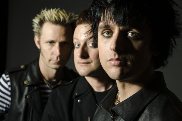 Billie Joe Armstrong and his band members pose for a portrait with serious expressions, 2K Desktop Wallpaper