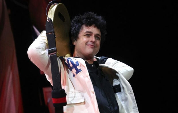 Billie Joe Armstrong is smiling while holding a guitar on stage, HD Desktop Wallpaper